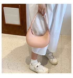 Pink crescent moon shoulder bag shown in detail by a model for a chic summer look
