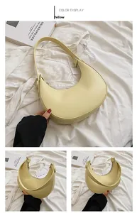 Detail view of a yellow crescent-shaped shoulder bag featuring matte leather texture