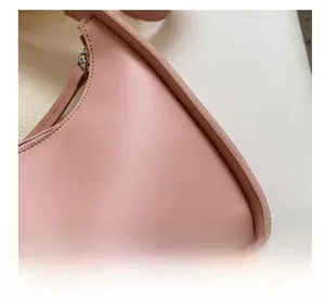 Close-up of pink leather handbag showing grainy texture and precision stitching details