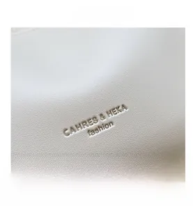 Detail of lychee pattern cream leather with embossed fashion logo and fine stitching