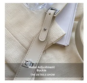 Detail of adjustable silver buckle on a beige leather strap of a crossbody bag