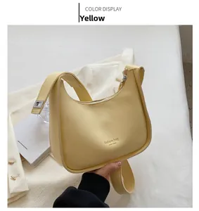 Detail of a bright yellow hobo bag with wide shoulder strap and New York logo print