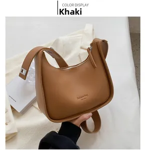 Detail view of khaki crescent shoulder bag with silver buckle and adjustable strap
