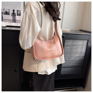 Side view of pink half-moon underarm bag with New York lettering on matte leather
