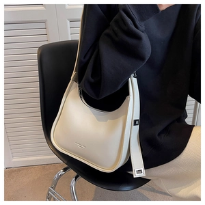 Detail of minimalist cream crescent bag with adjustable silver buckle strap and PU leather