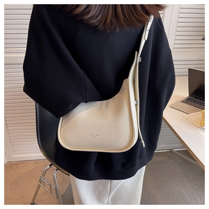 Chic beige half-moon crossbody bag shown on model with adjustable strap detail