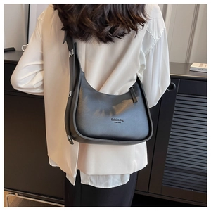 Detail of black matte leather crescent bag with silver buckle and embossed New York text
