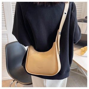 Detail of the minimalist beige crescent hobo bag with wide shoulder strap and silver buckle