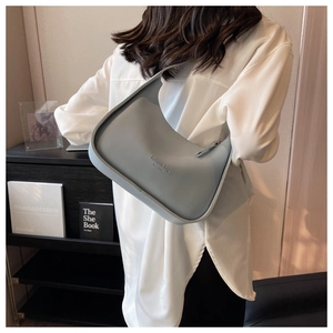 Detail of light blue crescent underarm bag with New York embossed text and zipper