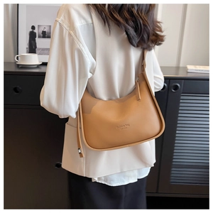 Detail of caramel leather underarm bag with embossed fashion bag New York text