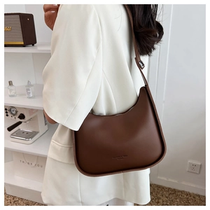 Macro detail of the crescent hobo bag in dark brown leather with adjustable shoulder strap