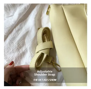 Close-up of adjustable shoulder strap with gold metal lobster clasp on a yellow tote bag