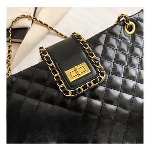 Detail showing black quilted leather tote bag with gold metal clasp and chain strap