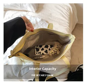 Detailed interior of large capacity yellow tote bag showing main pocket and side pouch