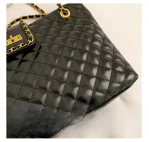 Close-up of black quilted leather tote with gold chain strap and metal swivel lock