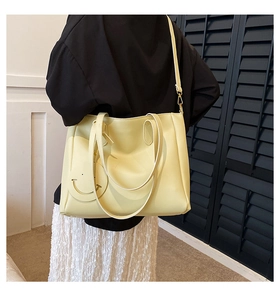 Detail of light yellow large tote bag showing shoulder strap and side view on a model