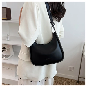 Rear view of a model wearing the matte black crescent moon shoulder bag with silver buckle