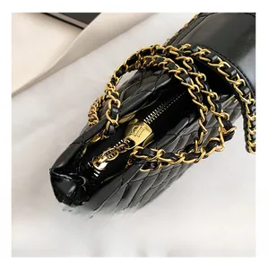 Detail of classic black quilted tote bag with golden metal chain strap and smooth zipper