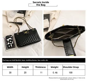 Detail view of large black quilted tote bag showing interior compartments and dimensions