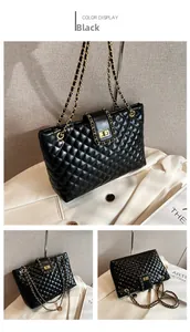 Detail view of black quilted tote bag with gold turn-lock and chain strap textures