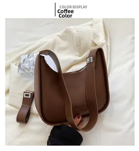 Detail of coffee brown U-shaped shoulder bag with silver hardware and smooth leather finish