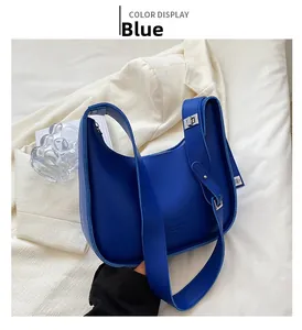 Detail of royal blue matte leather hobo bag with wide strap and silver metal buckle