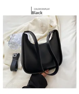 Detail of black crescent shoulder bag with silver hardware and adjustable strap