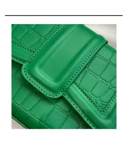 Macro detail of bright green faux crocodile leather bag showing high-quality stitching