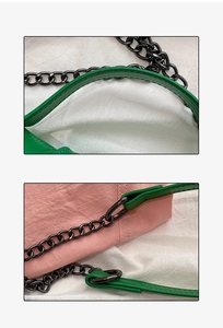 Detail of green leather strap with matte black metal chain on pink textured bag