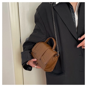 Detailed close-up of brown crocodile texture leather bag with elegant metal chain strap