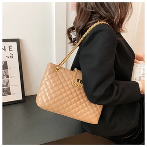 Macro shot of quilted diamond stitching on the khaki faux leather tote bag with gold chain