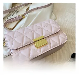 Close-up of a pink quilted shoulder bag featuring a rectangular gold metal twist-lock