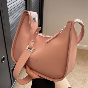 Pink crescent hobo bag with New York print and silver hardware held by hand