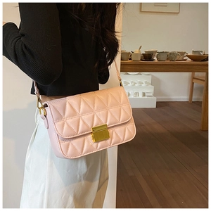 Detail of pink quilted shoulder bag featuring gold metal lock and leather texture
