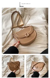 Close-up of brown faux leather saddle bag with D-ring buckle and adjustable strap