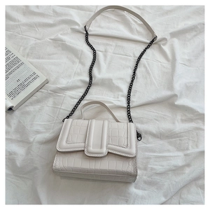 Detail view of white crocodile pattern shoulder bag with metallic chain and handle