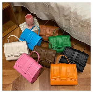 Detailed close-up of croc-embossed textured crossbody bags in eight fashion-forward colors
