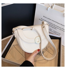 Unboxing of a creamy white saddle bag in a premium gift box with matching dust bag