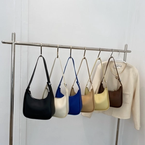 Minimalist hobo underarm bags in six assorted colors hanging on a metal rack