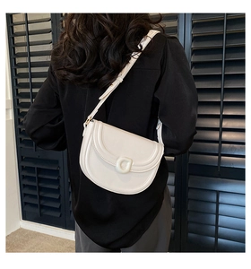Minimalist white leather saddle bag with D-ring buckle on a shoulder model view