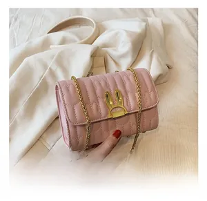 Detailed shot of pink crossbody bag featuring wave quilting and golden bunny ear clasp