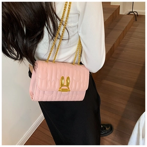 Detailed back view of pink crossbody bag with rabbit embossed texture and gold chains