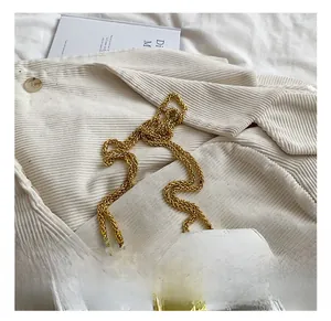 Close-up of white quilted bag featuring a golden rabbit-ear lock and thick chain