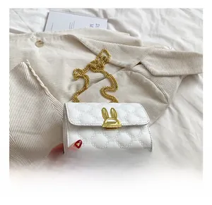 Detail of white heart-quilted leather bag with golden bunny-ear clasp and chain strap