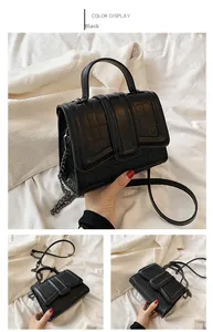 Detail of black crocodile pattern crossbody bag with round handle and metal chain strap
