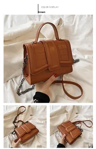 Detail view of brown crocodile texture leather and dark gunmetal chain strap hardware