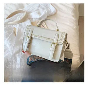 Détail du sac bandoulière crème vintage avec broderie épi et sangle à motif ethnique