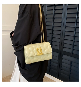 Detail of cream quilted bag with heart stitching and golden rabbit ear twist lock