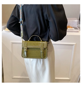 Modèle portant un sac bandoulière vert rétro avec une large sangle florale style bohème