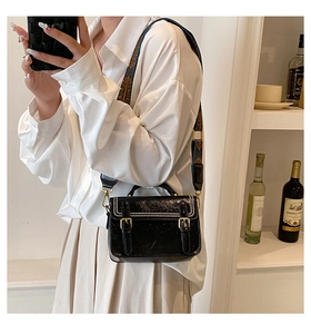 Détail du sac à bandoulière en cuir PU noir avec boucles dorées et sangle large